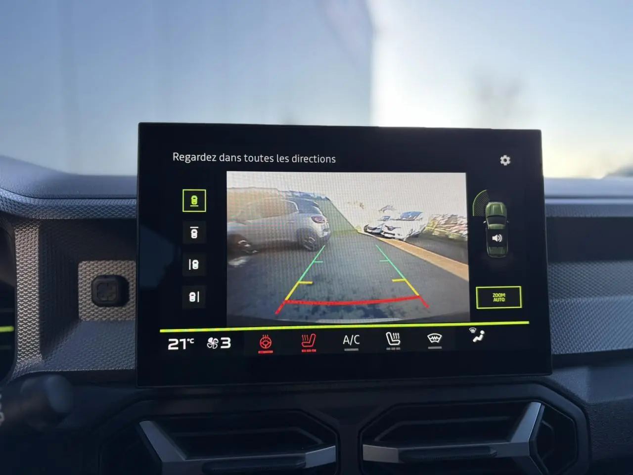 Écran tactile central affichant la caméra 360° du Dacia Duster noir nacré, vue arrière en stationnement.