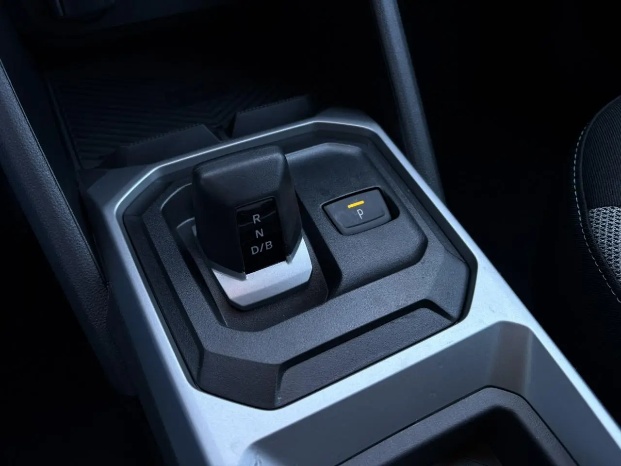 Gros plan sur le levier de vitesses automatique et bouton parking du Dacia Duster 2025 intérieur noir et gris.
