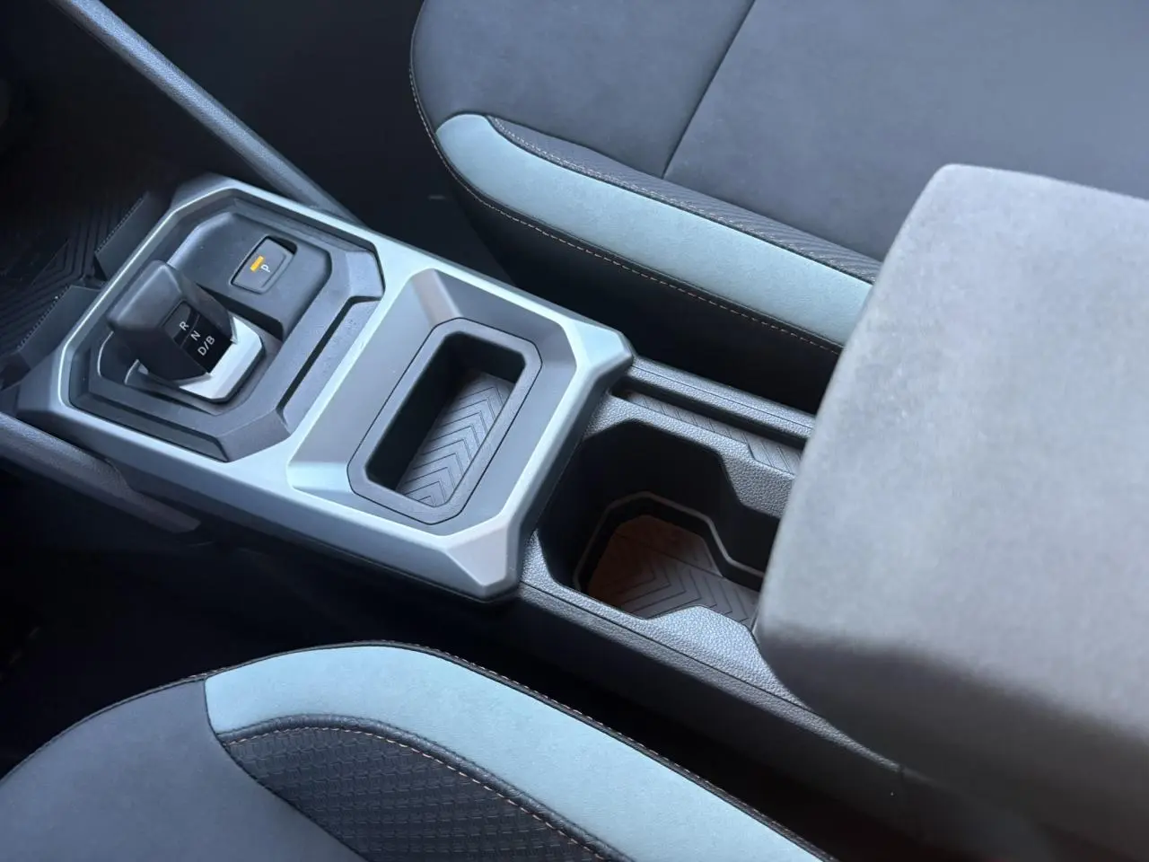 Vue rapprochée de la console centrale et du levier de vitesse de la Dacia Duster 2025, intérieur noir et gris.
