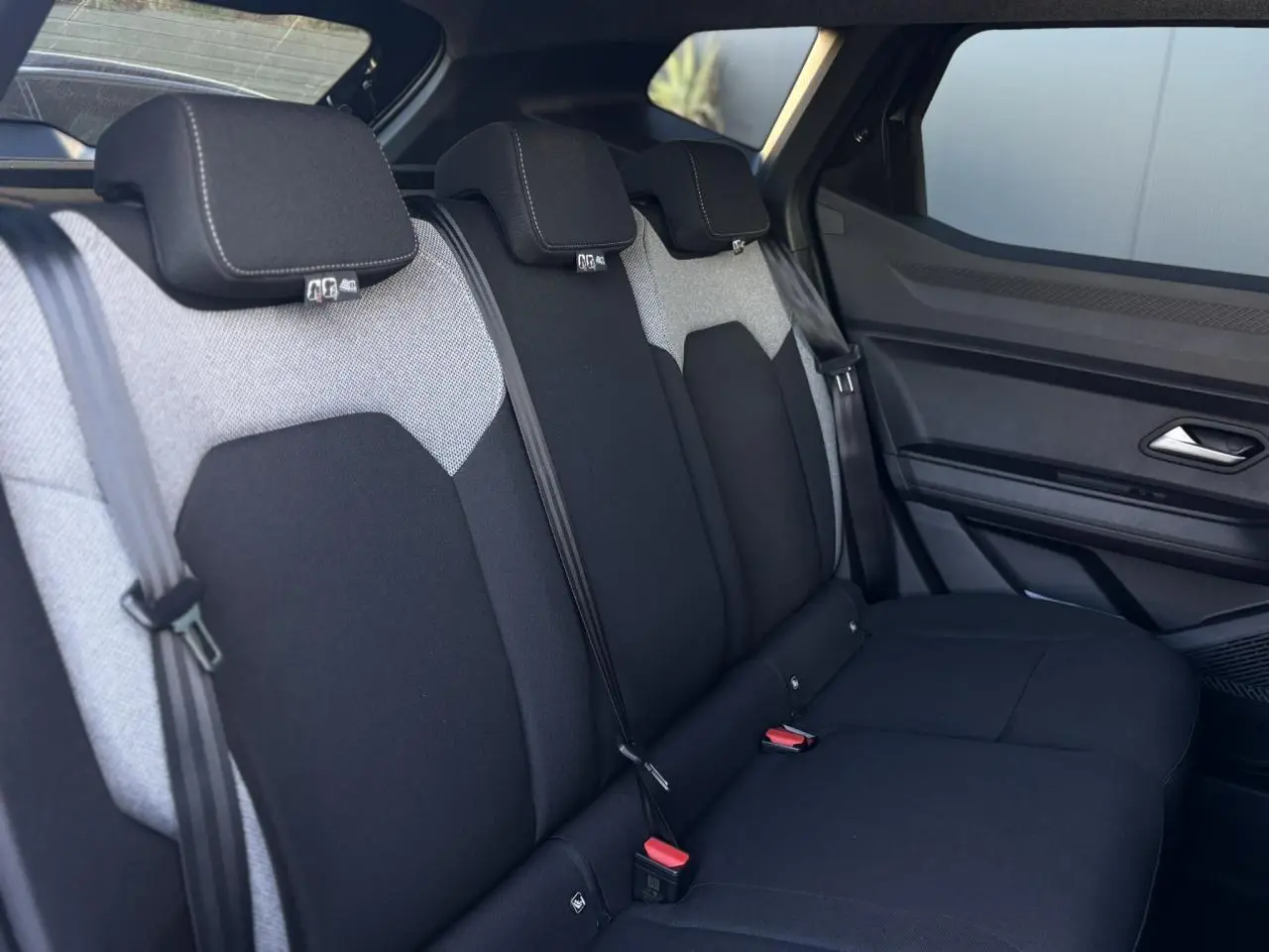 Vue latérale intérieure des sièges arrière bicolores gris et noir du Dacia Duster 2025 côté droit.