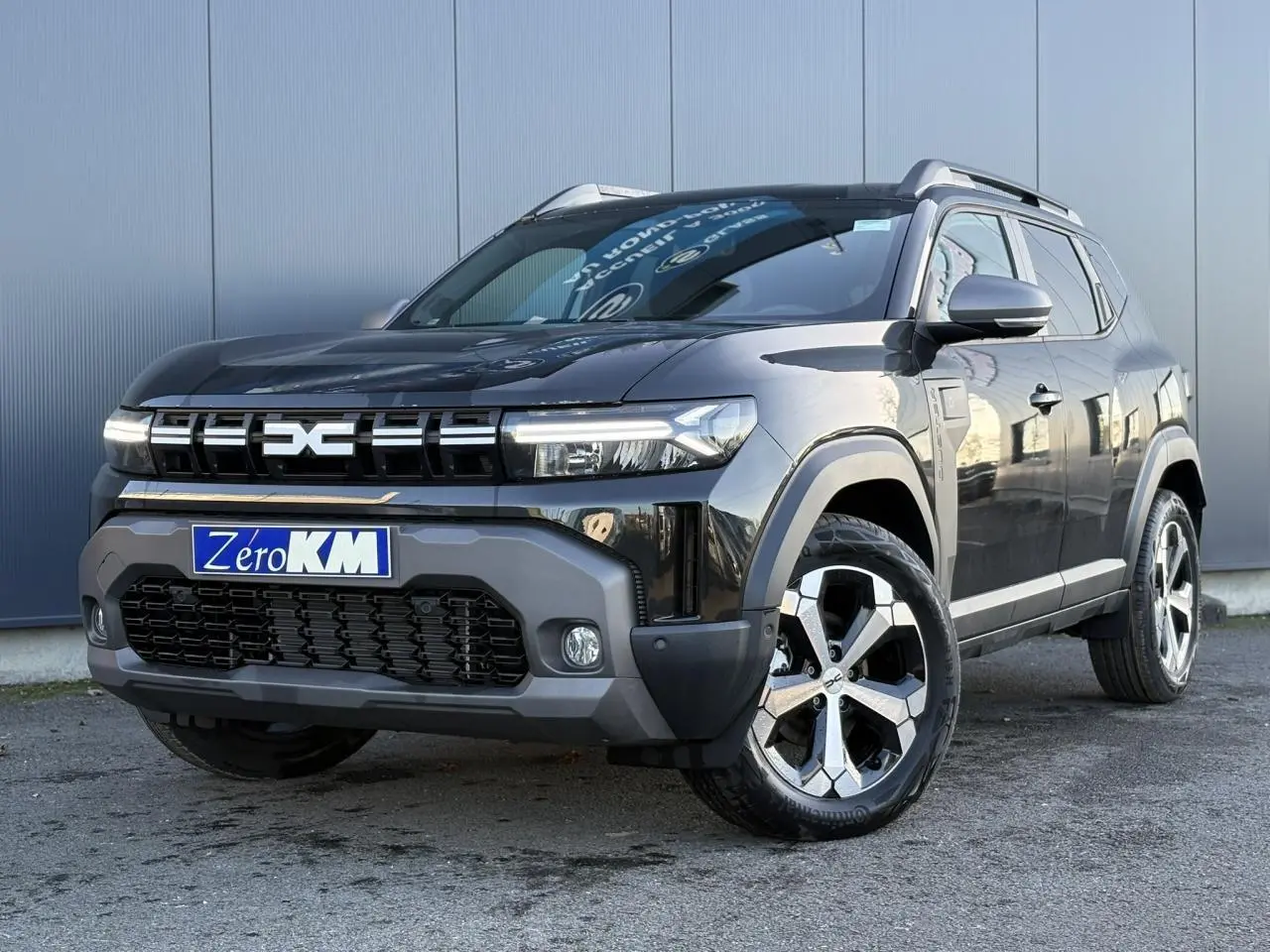 Vue 3/4 avant droit du Dacia Duster 2025 noir nacré avec jantes alliage diamantées et signature lumineuse LED.