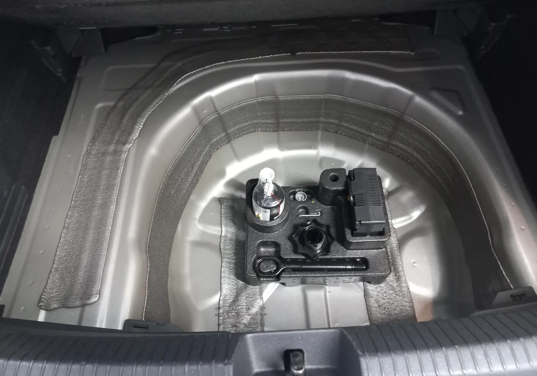 Coffre ouvert en vue plongeante montrant le rangement sous plancher du Volkswagen Taigo 2025 couleur Reflet d'argent.