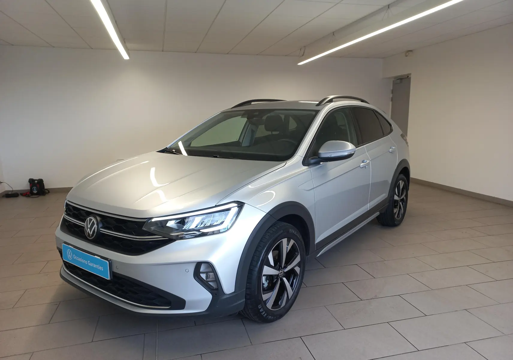 Volkswagen Taigo 2025 en reflet d'argent, vue 3/4 avant droit avec jantes alliage et projecteurs antibrouillard.