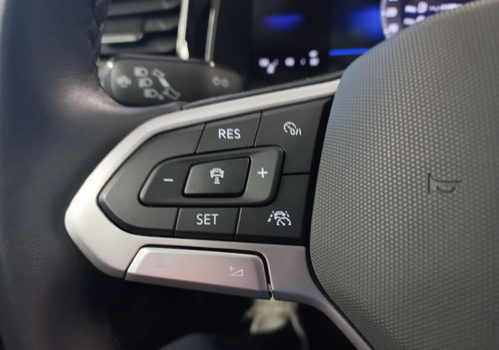 Gros plan sur les commandes au volant côté gauche du Volkswagen Taigo 2025, finition VW Edition, avec détails en argent mat.