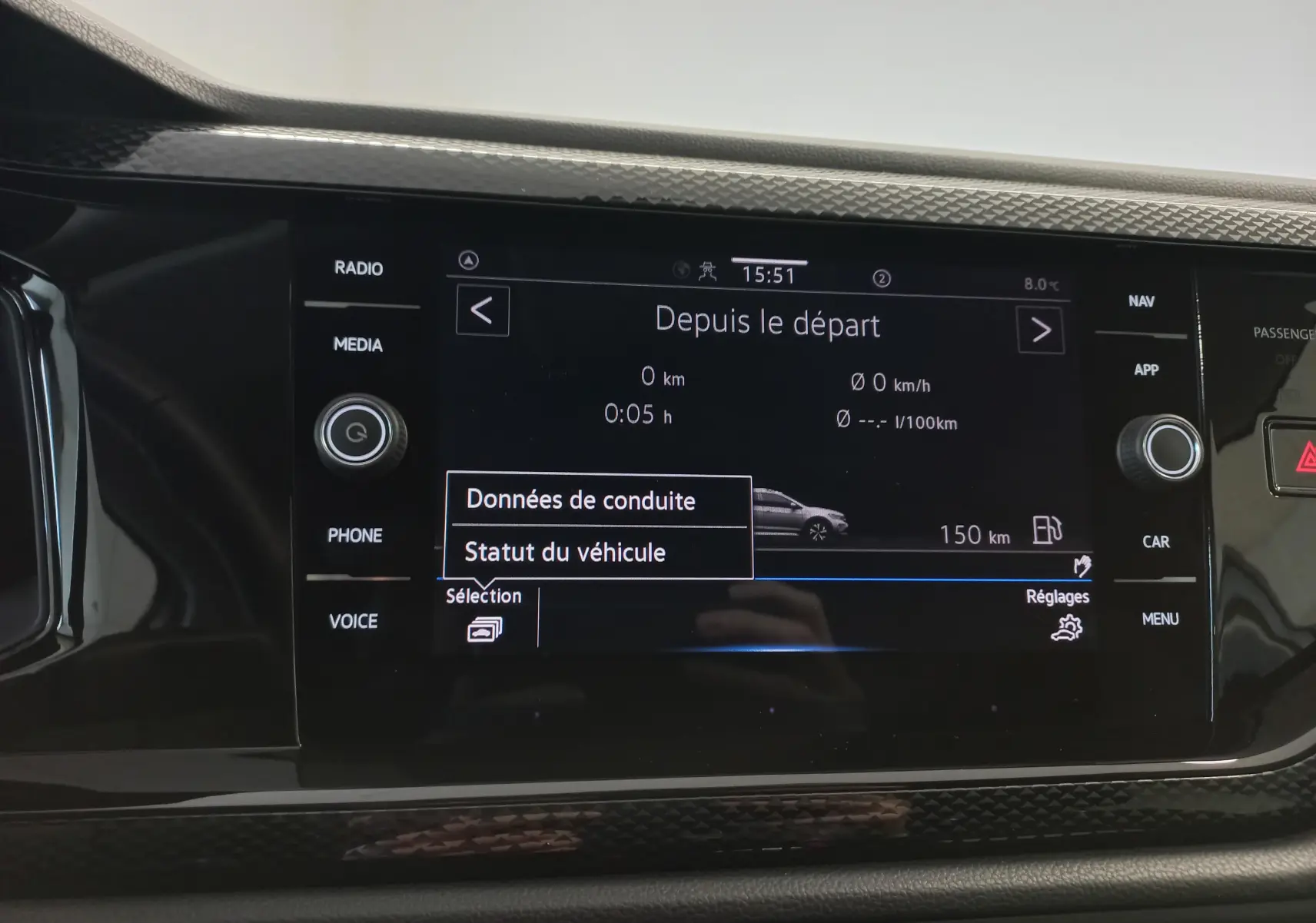 Écran tactile central du Volkswagen Taigo 2025 affichant les données de conduite, entouré de boutons de commande noirs.