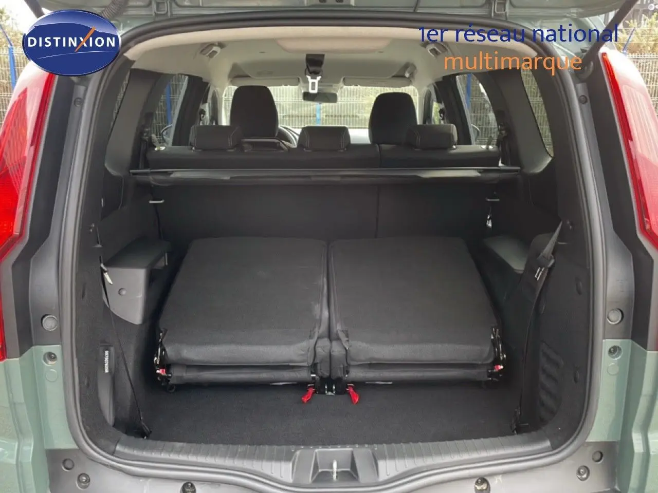 Vue arrière du coffre ouvert du Dacia Jogger kaki lichen avec sièges rabattus et espace de chargement visible.