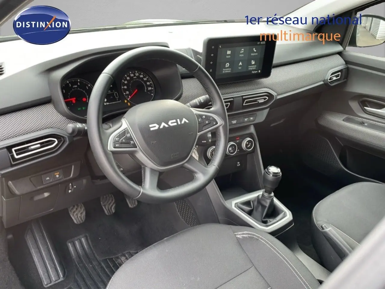 Vue intérieure côté conducteur du Dacia Jogger 2025, montrant le volant, tableau de bord et levier de vitesses manuelle.