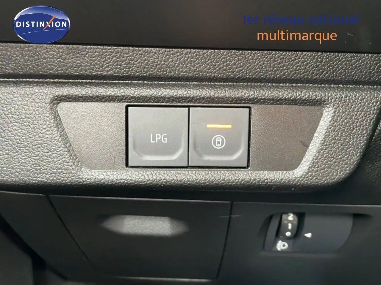 Gros plan sur les boutons de commande LPG et verrouillage, intérieur noir texturé du Dacia Jogger kaki lichen 2025.