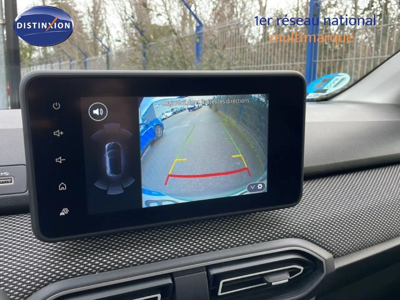 Écran tactile intérieur montrant la caméra de recul avec guidage, sur tableau de bord au design texturé noir.
