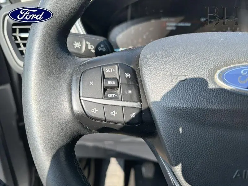 Gros plan sur le volant cuir multifonction noir du Ford Kuga 2020 avec commandes de régulateur et limitation de vitesse.