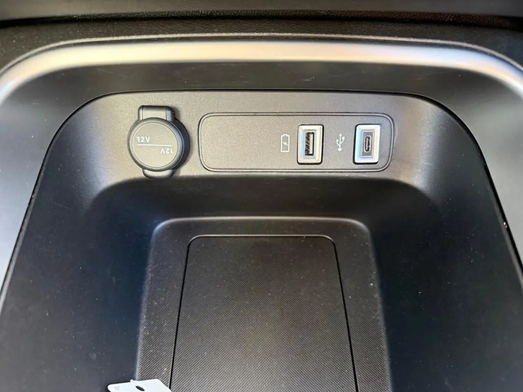 Prise USB et prise 12V en gros plan dans la console centrale du Jeep Avenger blanc, version 2025.