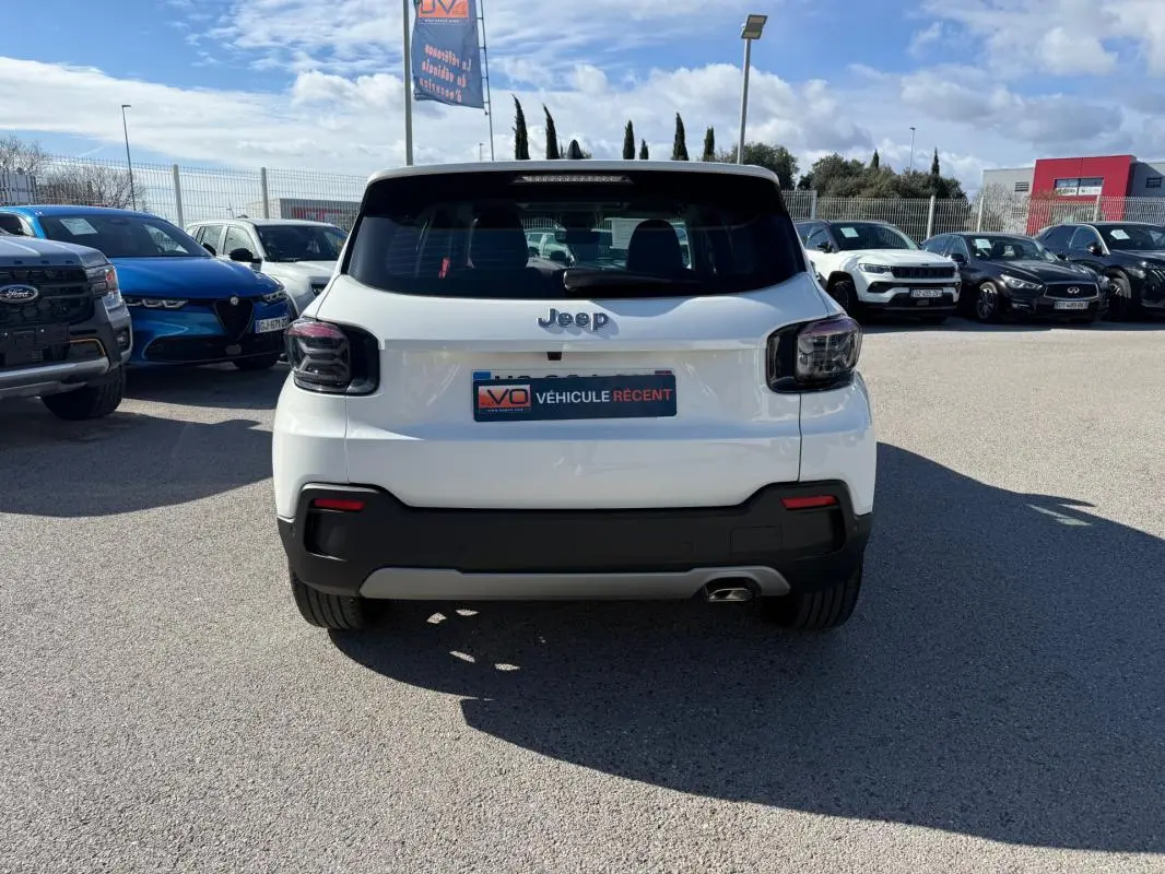 Vue arrière d’un Jeep Avenger blanc 2025 avec feux arrière fumés et pare-chocs noir contrastant.