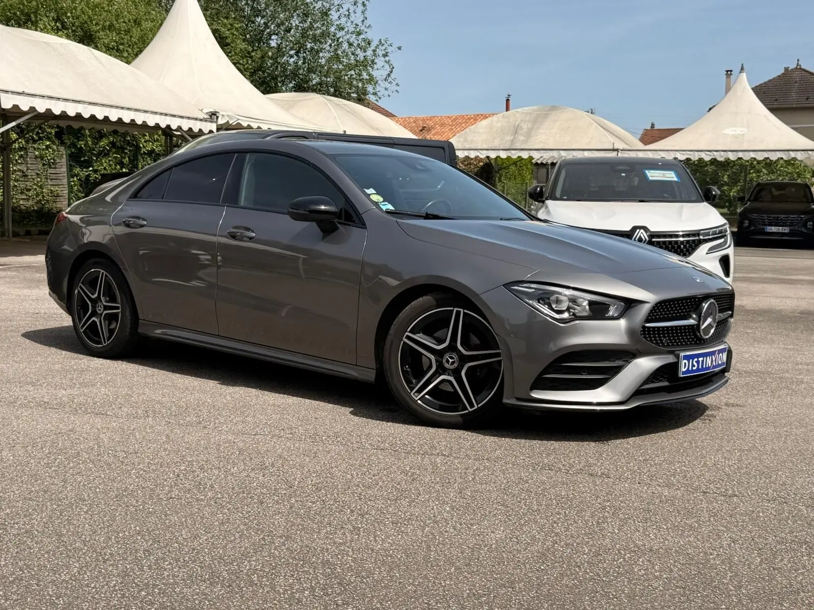 Mercedes Classe CLA 180 D AMG Line gris montagne vue 3/4 avant droit avec jantes étoile noires et vitres teintées.
