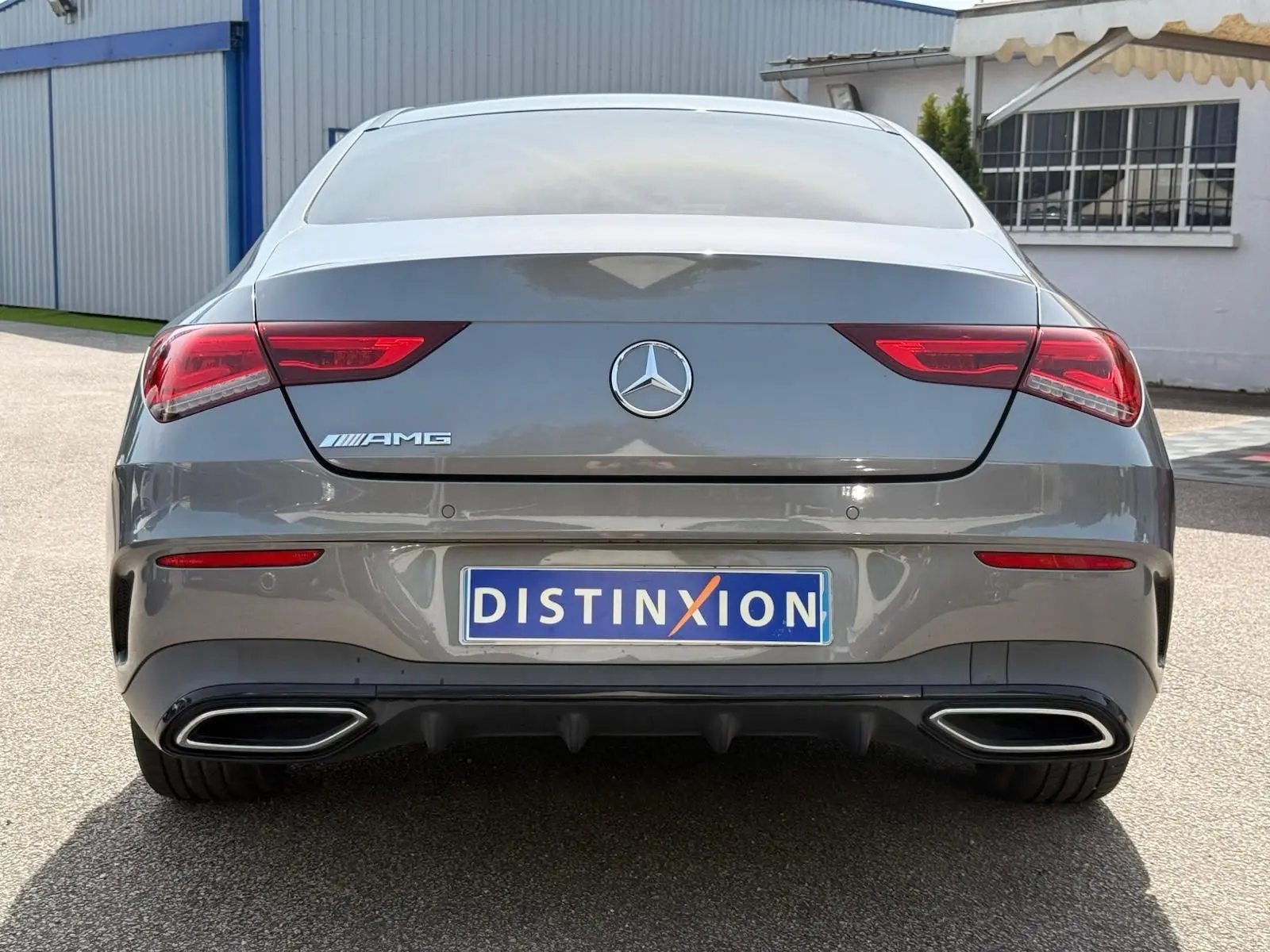 Vue arrière d’une Mercedes Classe CLA 180 D AMG Line gris montagne avec feux LED et double sortie d’échappement chromée.