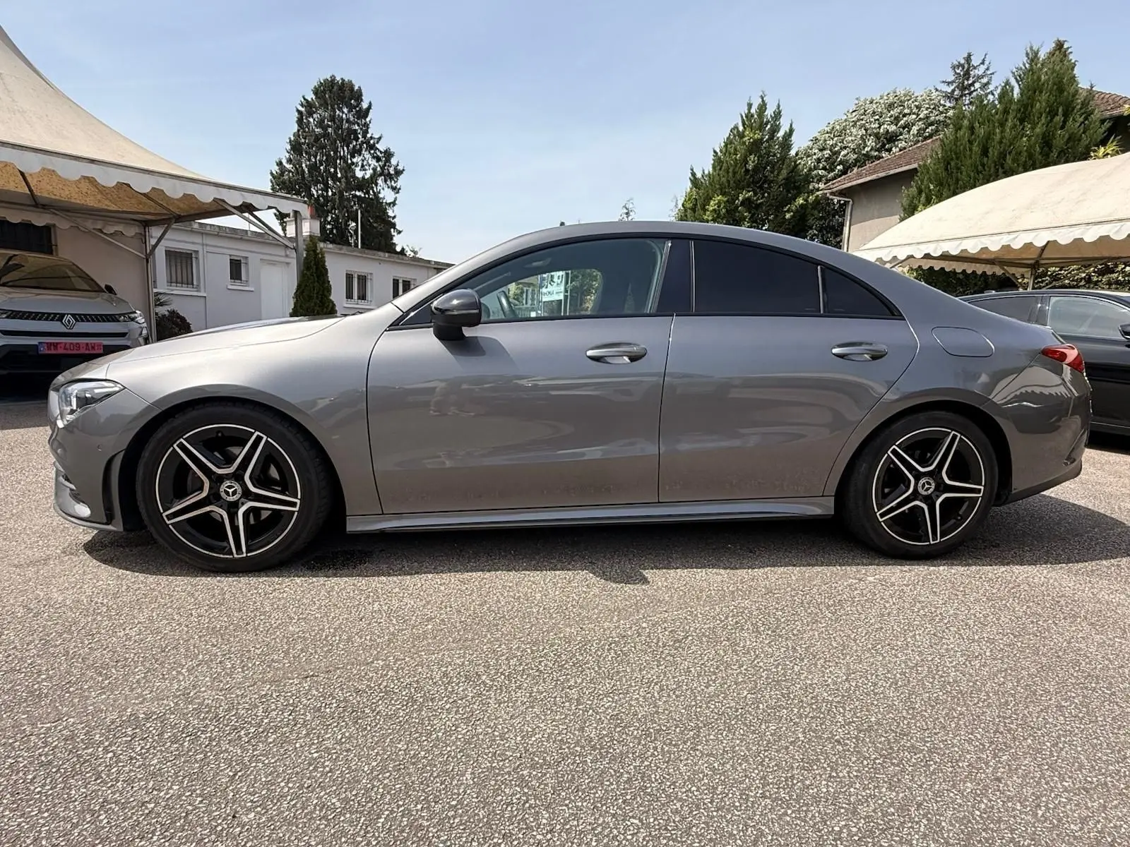 Vue de profil côté gauche d'une Mercedes Classe CLA 180 D AMG Line gris montagne avec jantes alliage noires et détails chromés.