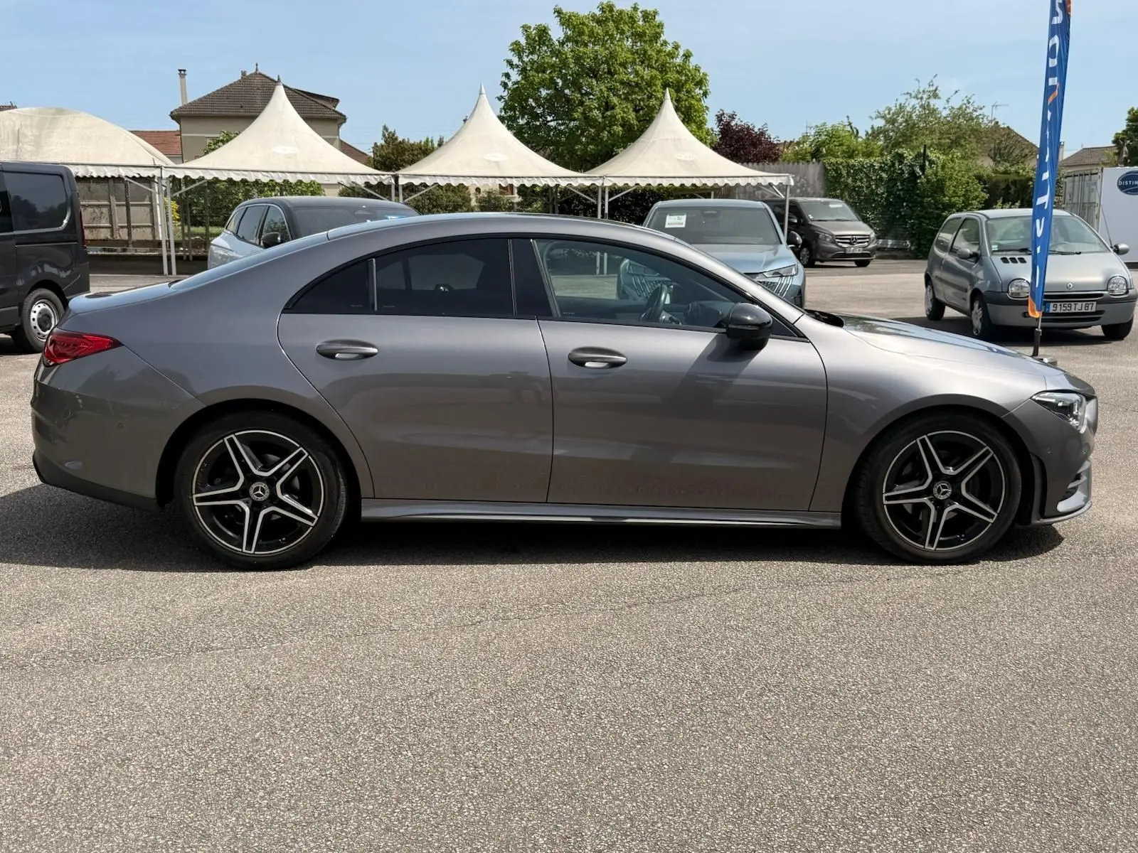 Vue de profil côté gauche d'une Mercedes Classe CLA 180 D AMG Line gris montagne avec jantes alliage noires.