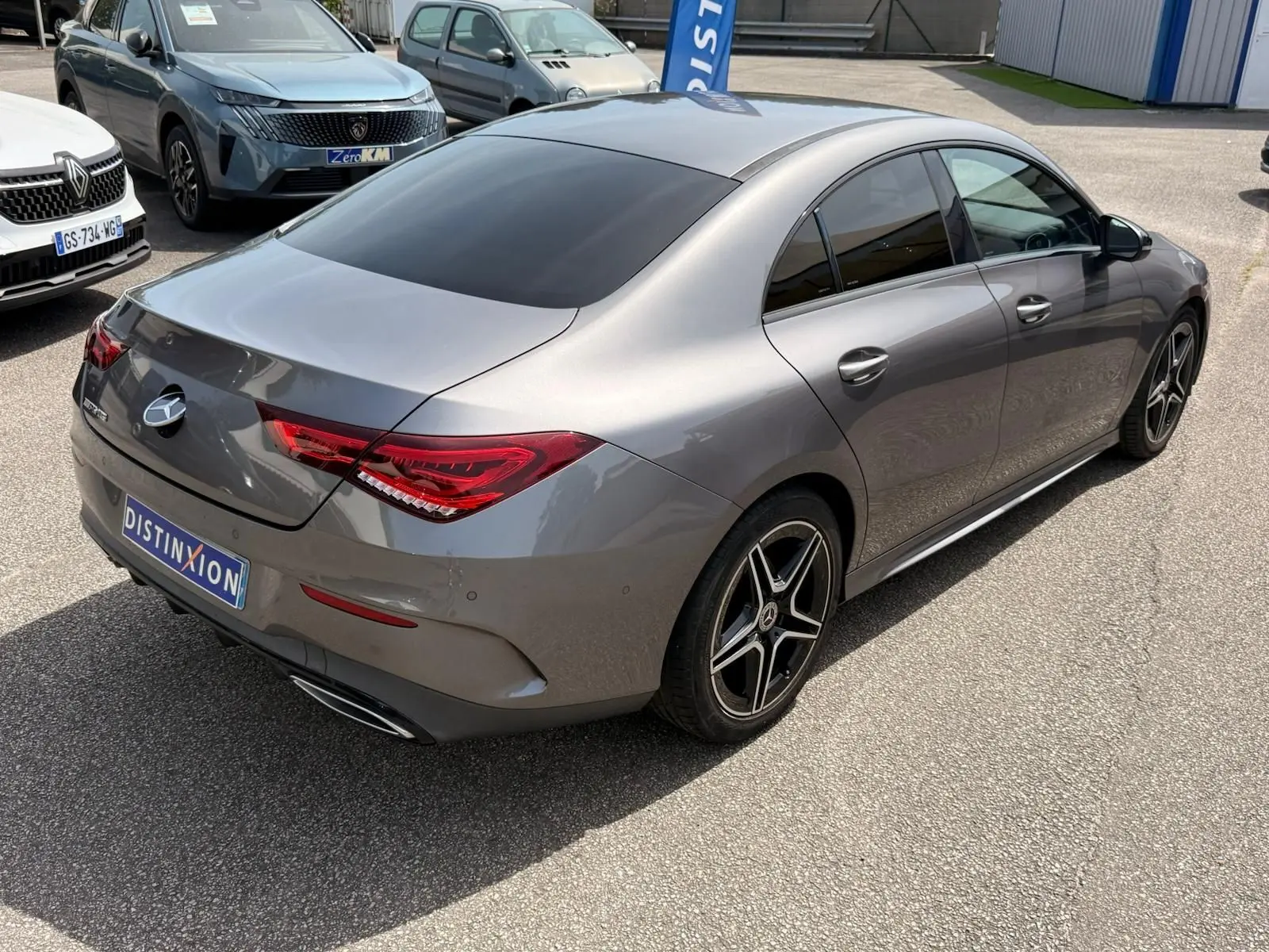 Vue 3/4 arrière droite d'une Mercedes Classe CLA 180 D AMG Line gris montagne avec jantes alliage noires et vitres teintées.