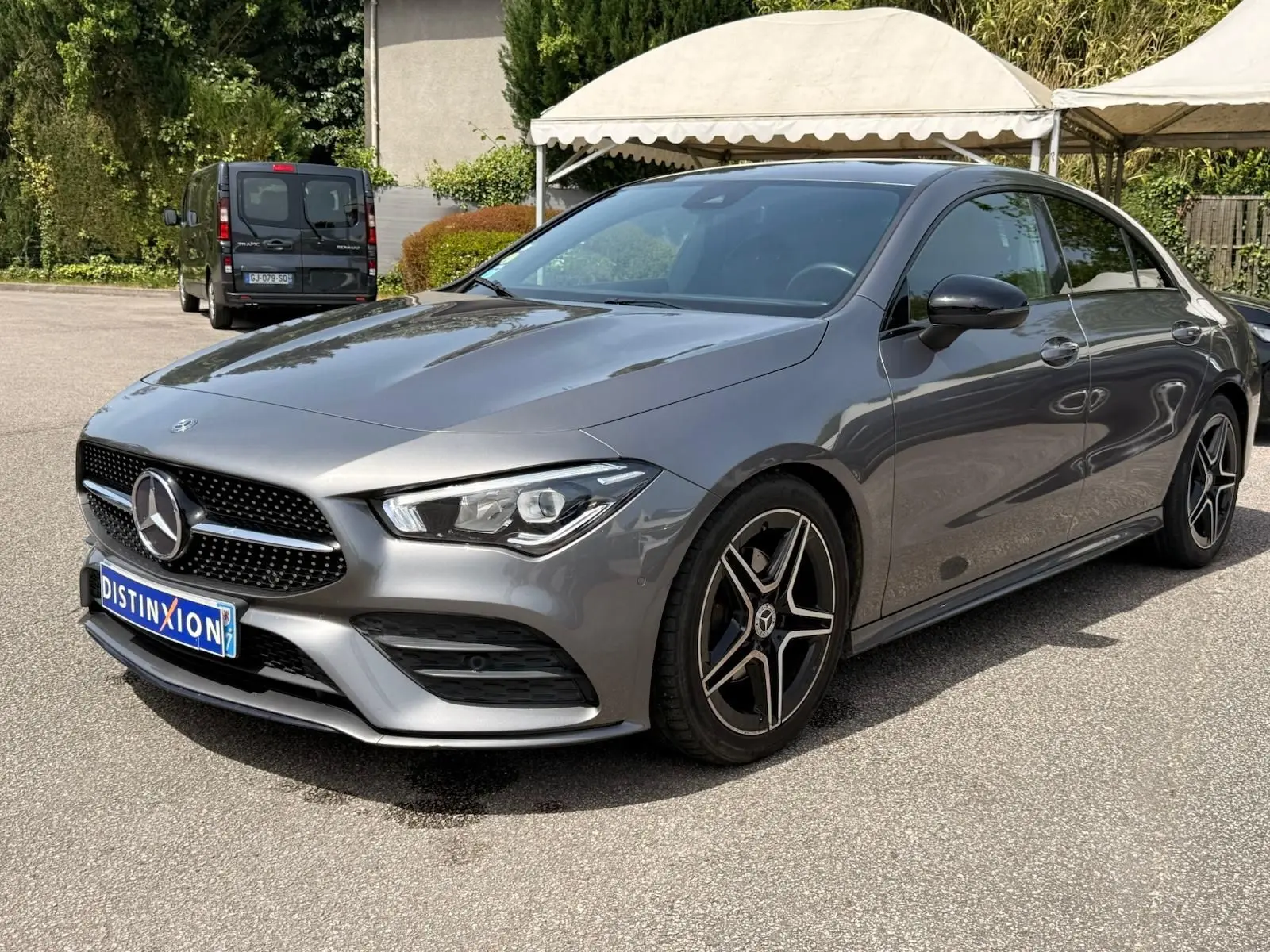 Vue 3/4 avant droit d'une Mercedes Classe CLA 180 D AMG Line gris montagne avec jantes étoile et calandre noire distinctive.
