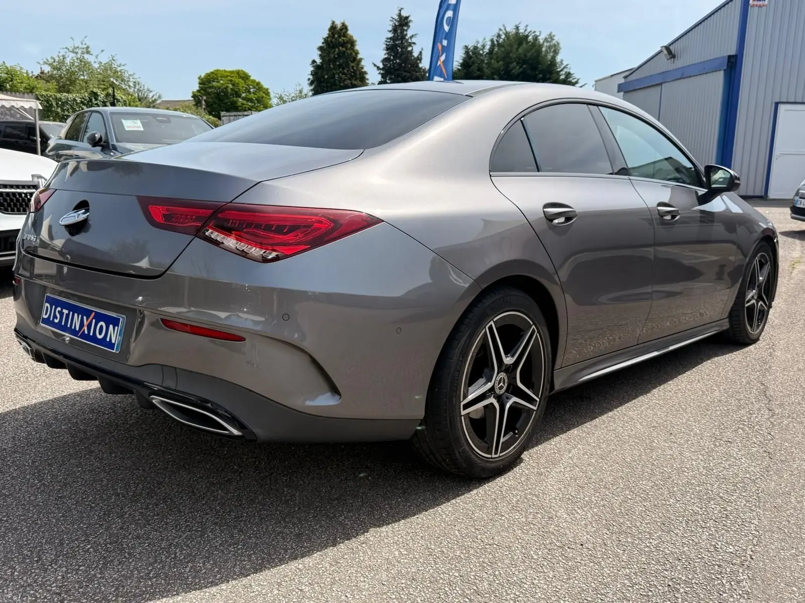 Vue 3/4 arrière droite d'une Mercedes Classe CLA 180 D AMG Line gris montagne avec jantes alliage et feux LED distinctifs.