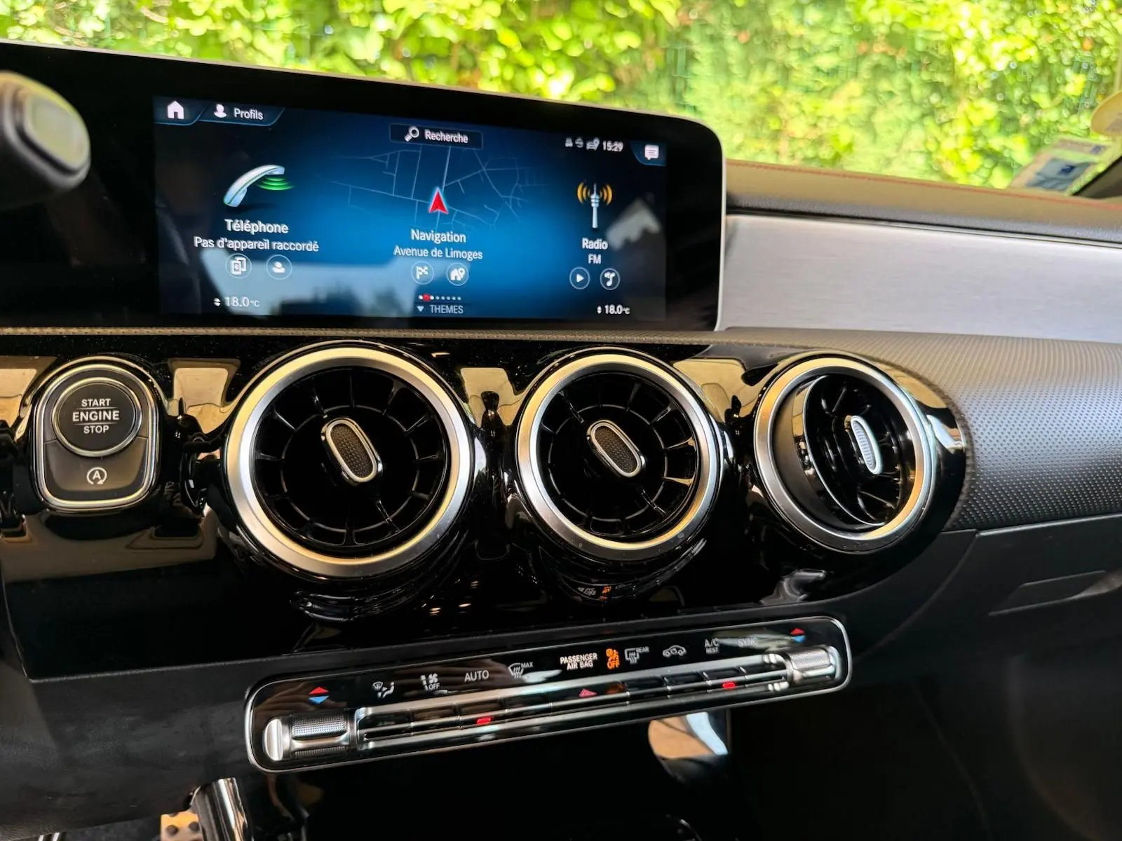 Vue rapprochée de la planche de bord de la Mercedes Classe CLA 180 D AMG Line 2019, avec écran tactile et aérateurs ronds noirs.
