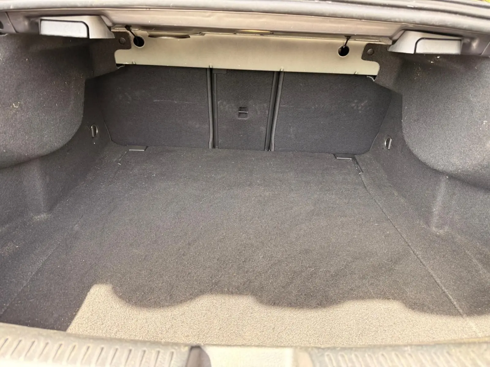 Coffre vide vu de face d’une Mercedes Classe CLA 180 D AMG Line gris montagne, intérieur en tissu noir.