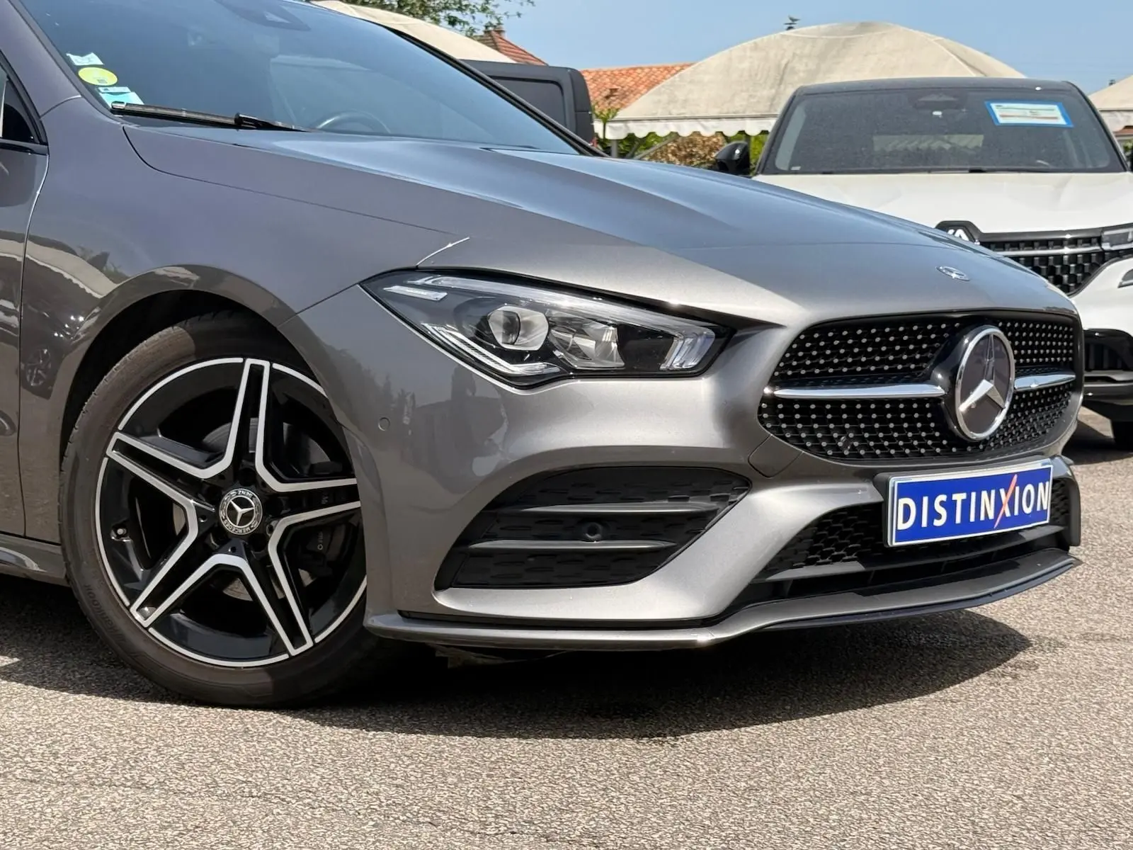 Vue 3/4 avant gauche d'une Mercedes Classe CLA 180 D AMG Line gris montagne avec jantes cinq branches noires et grises.