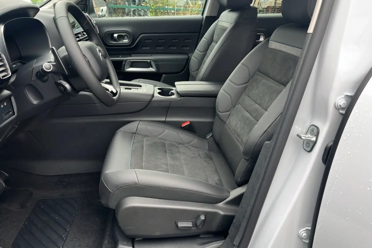 Vue intérieure côté conducteur du Citroën C5 Aircross blanc, sièges en cuir et alcantara avec console centrale visible.