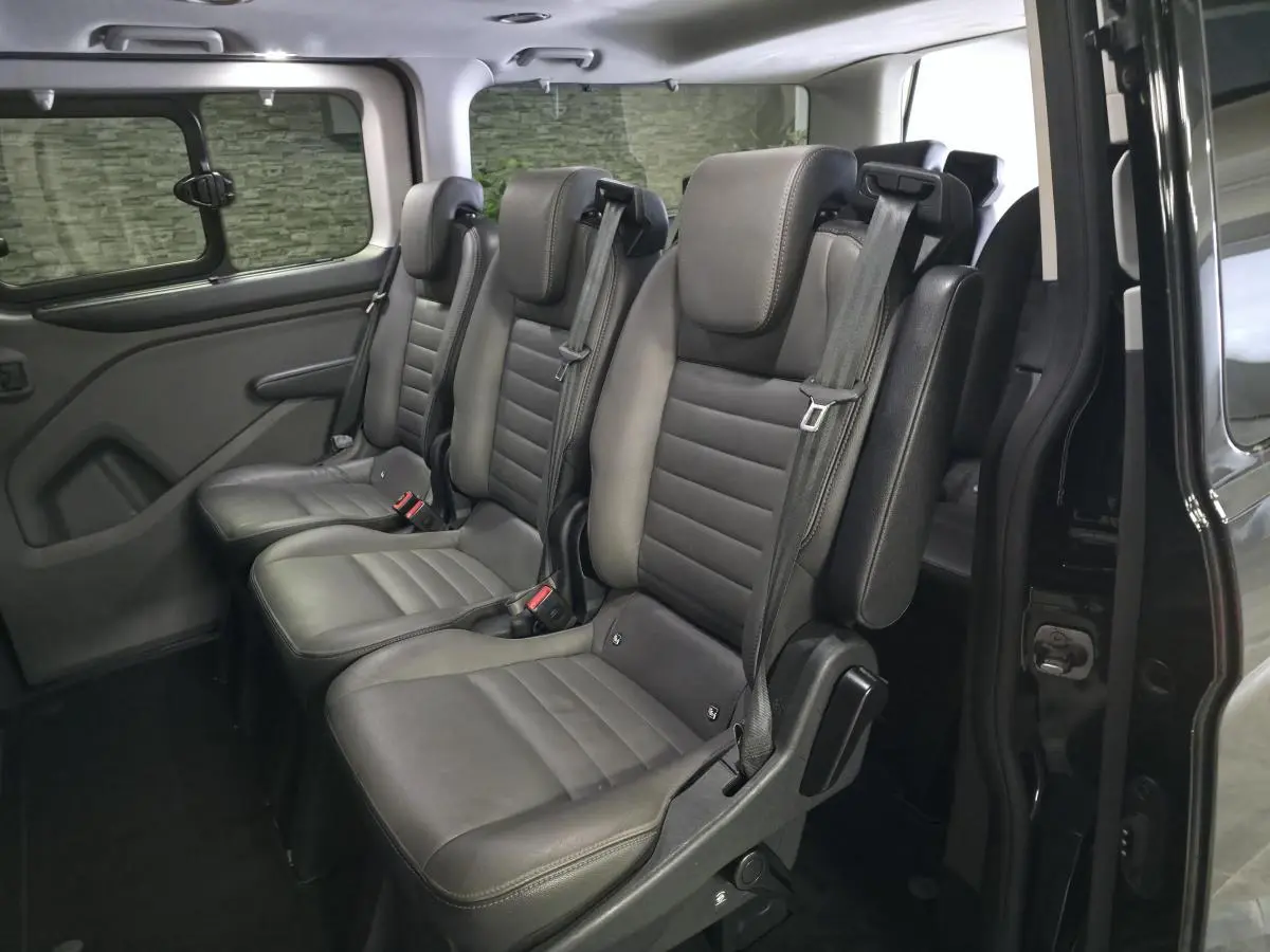 Vue intérieure côté droit sur les sièges en cuir gris anthracite du Ford Transit Fourgon Custom 2022 noir.