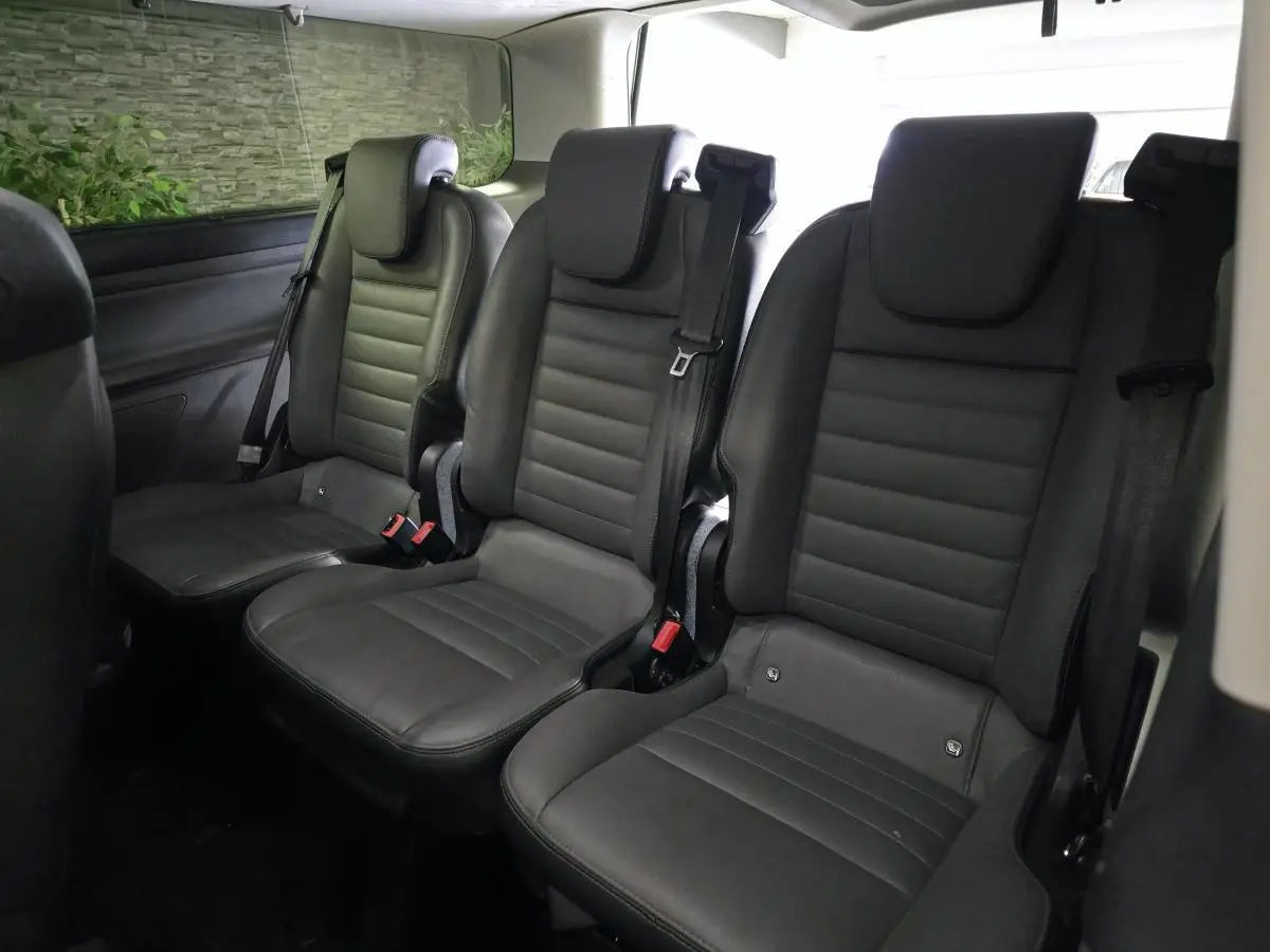 Vue intérieure sur la rangée arrière de trois sièges individuels en cuir gris anthracite du Ford Transit Custom noir.