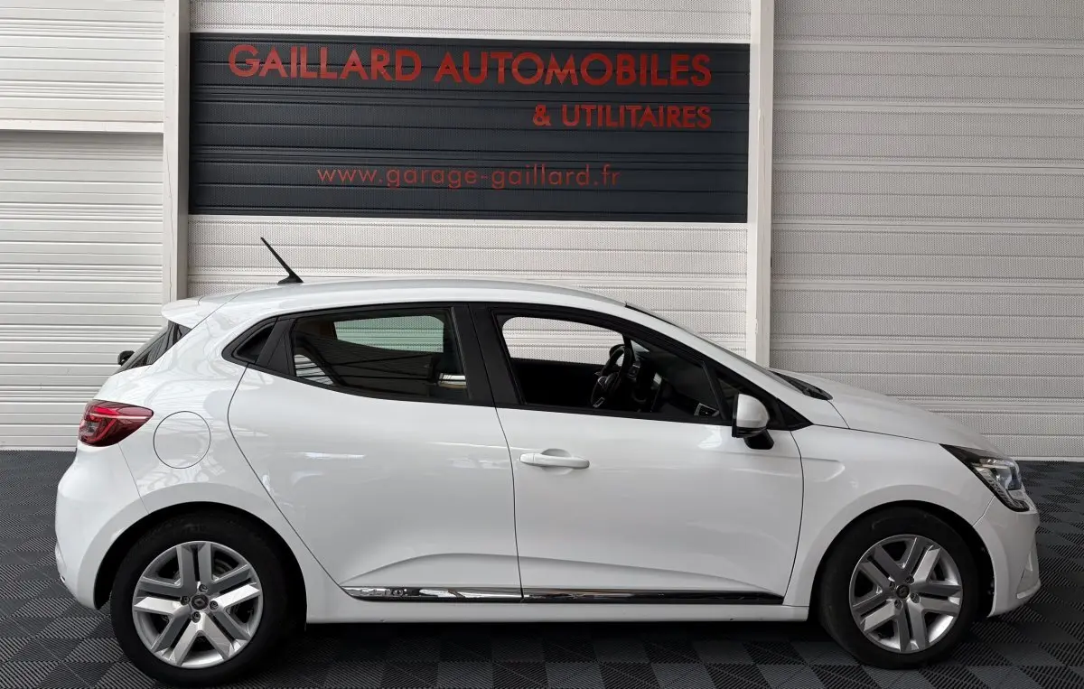 Profil droit d'une Renault Clio Business E-Tech hybride blanche 2022, avec jantes alliage et rétroviseurs électriques.