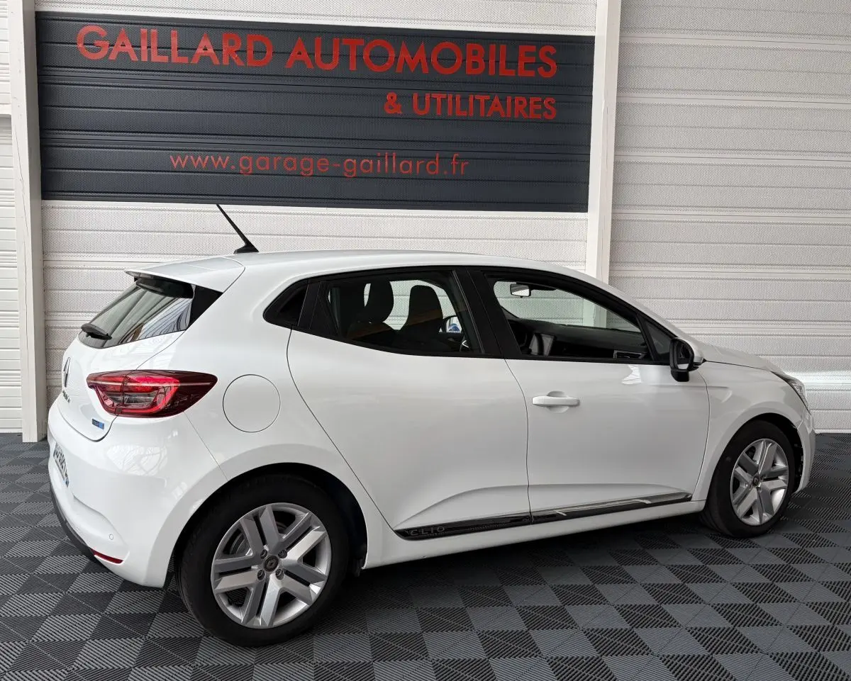 Renault Clio Business E-Tech hybride blanc vue de profil côté gauche, avec jantes alliage et logo Clio sur bas de porte.