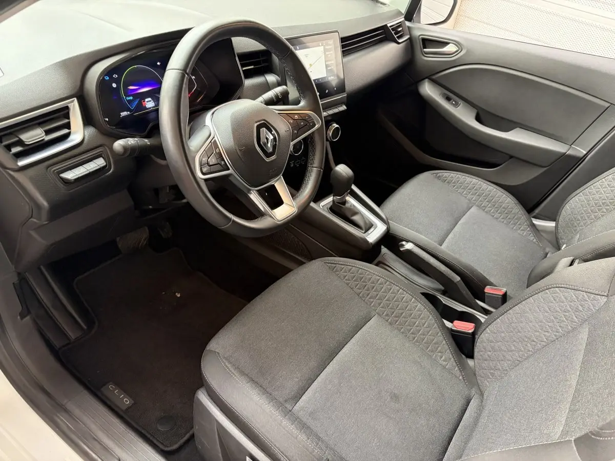 Vue intérieure côté conducteur de la Renault Clio Business E-Tech 2022, volant cuir multifonctions et sièges tissu gris.
