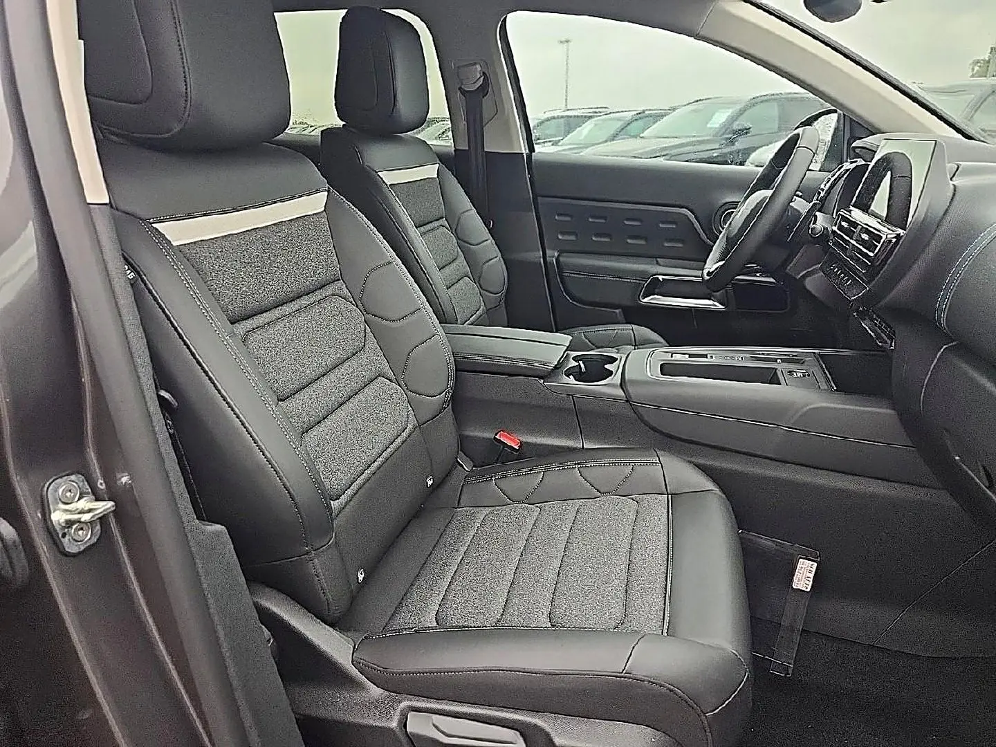 Vue intérieure côté conducteur du Citroën C5 Aircross gris 2025, sièges en cuir et tissu avec console centrale visible.