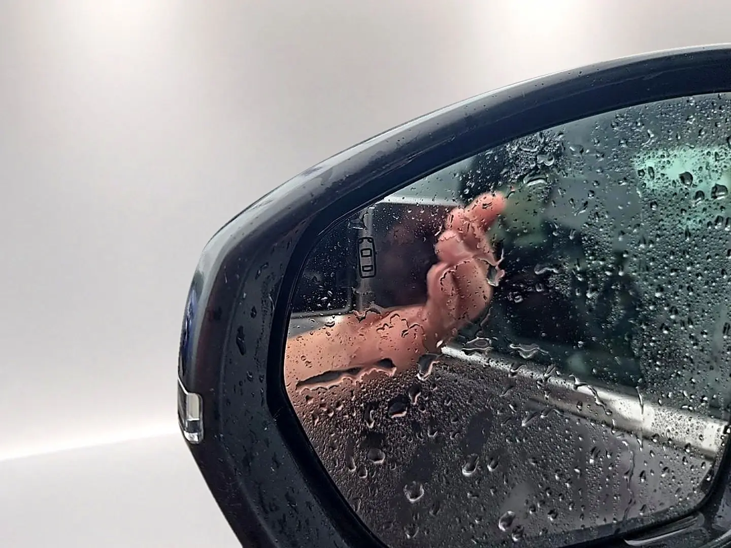 Rétroviseur droit gris du Citroën C5 Aircross 2025 avec gouttes d'eau et reflet partiel de la carrosserie.