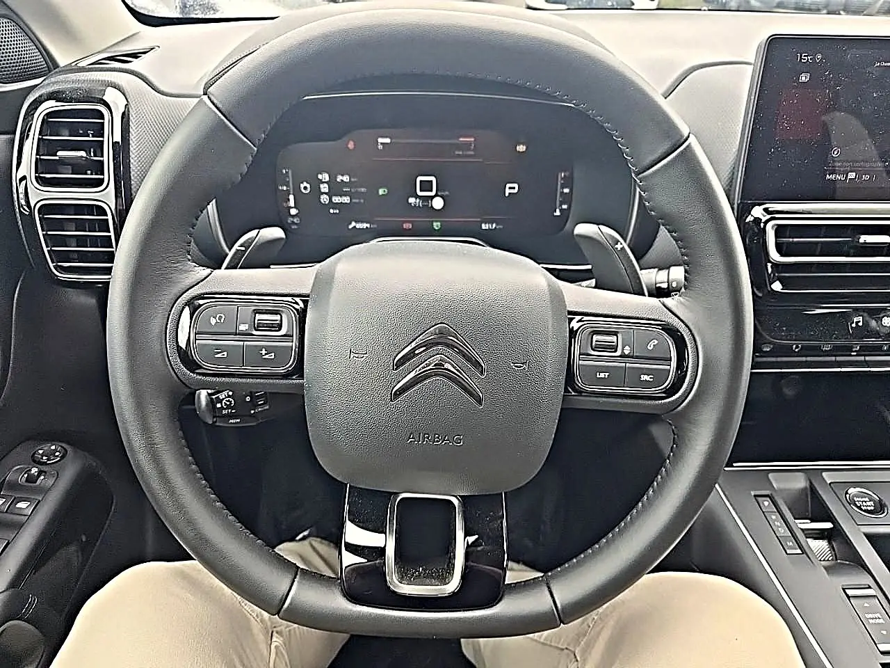 Vue intérieure centrée sur le volant cuir noir du Citroën C5 Aircross 2025 avec tableau de bord digital et écran tactile.