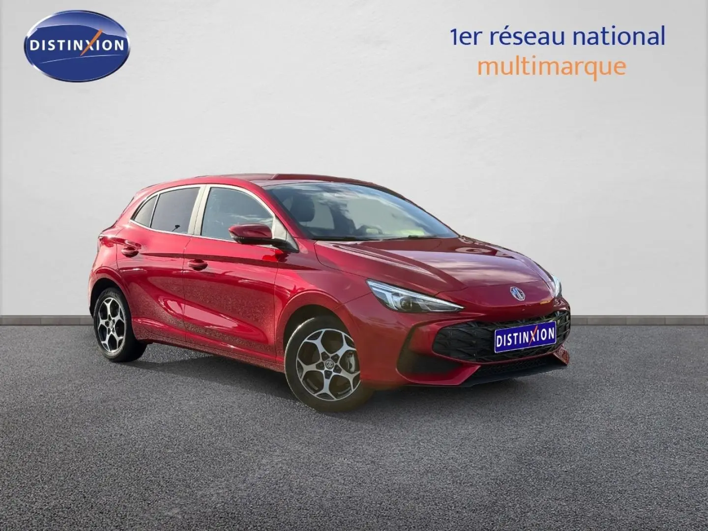 MG3 1.5 Hybrid+ 195ch Luxury en Diamond Red métallisé, vue 3/4 avant avec jantes alu distinctives.