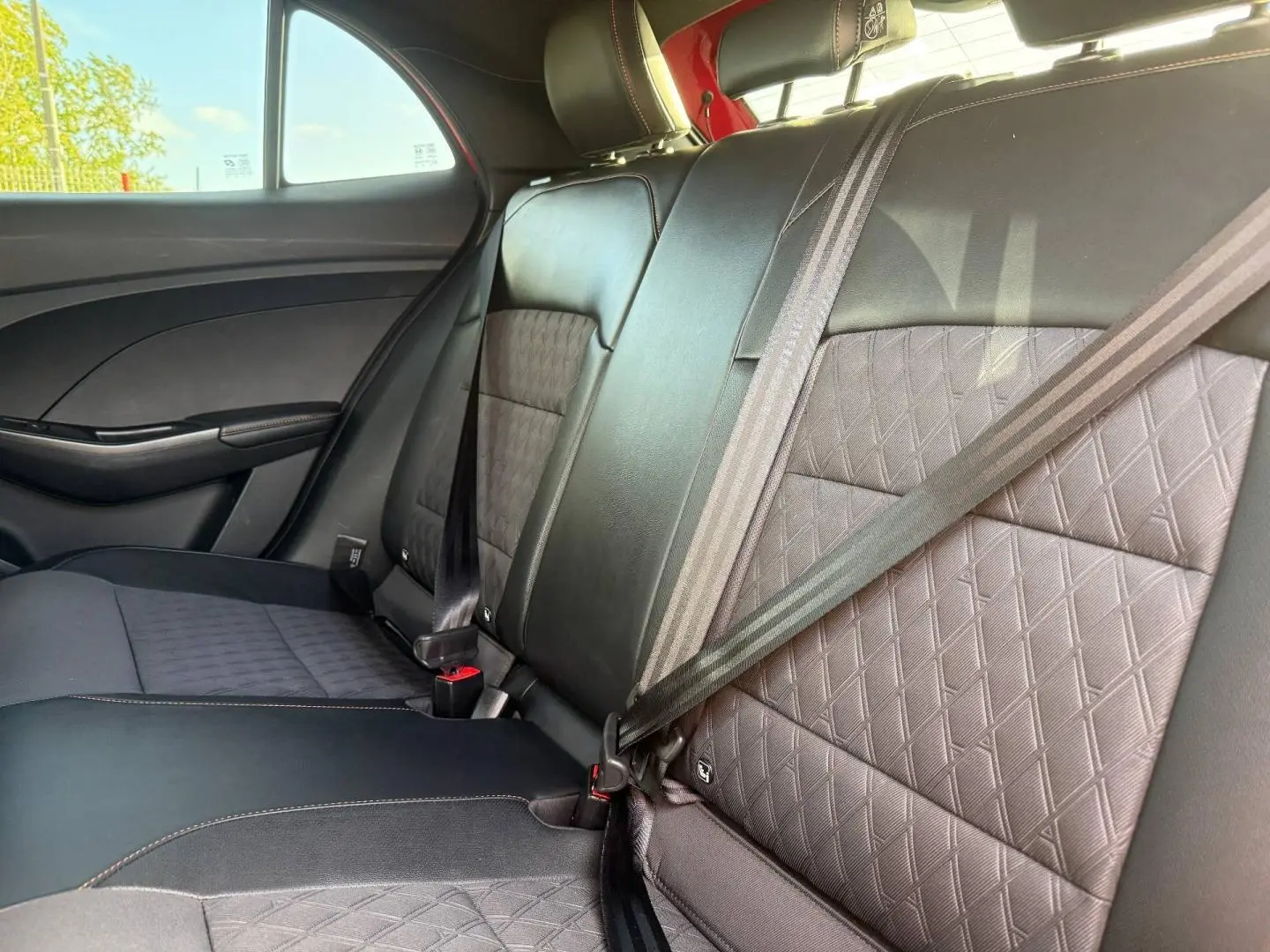 Vue intérieure de la banquette arrière en similicuir noir et tissu avec ceintures de sécurité dans une MG3 1.5 Hybrid+ 2025.
