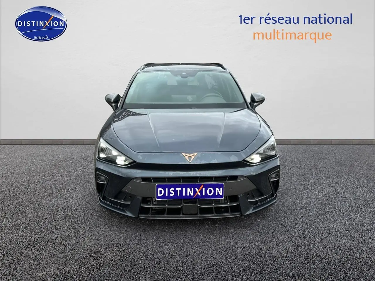 Vue avant d'une CUPRA LEON ST 1.5 etsi hybrid gris magnétique avec phares LED allumés sur fond neutre.