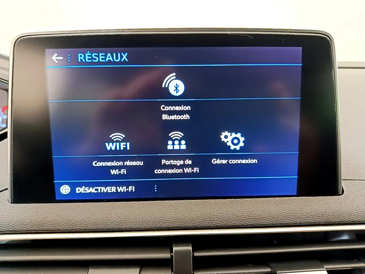 Écran tactile central affichant les options réseau Wi-Fi et Bluetooth dans le tableau de bord du Peugeot 3008.
