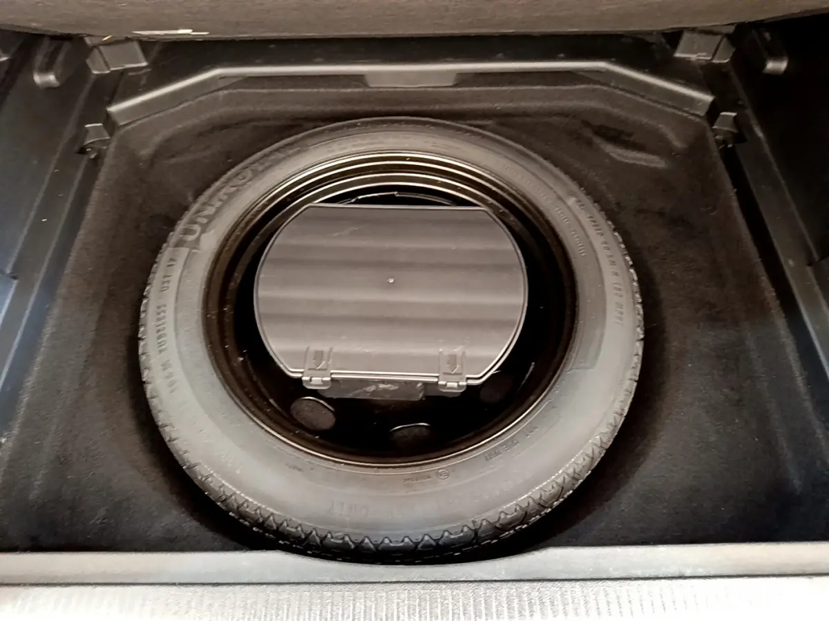 Vue plongeante sur la roue de secours dans le coffre noir du Peugeot 3008 gris foncé Puretech 130 S&S ACTIVE 2020