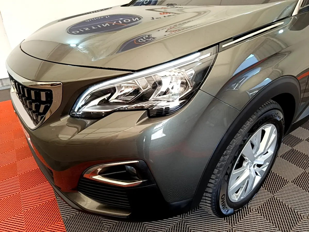 Vue 3/4 avant droit d'un Peugeot 3008 gris foncé mettant en valeur son phare LED et sa calandre distinctive.