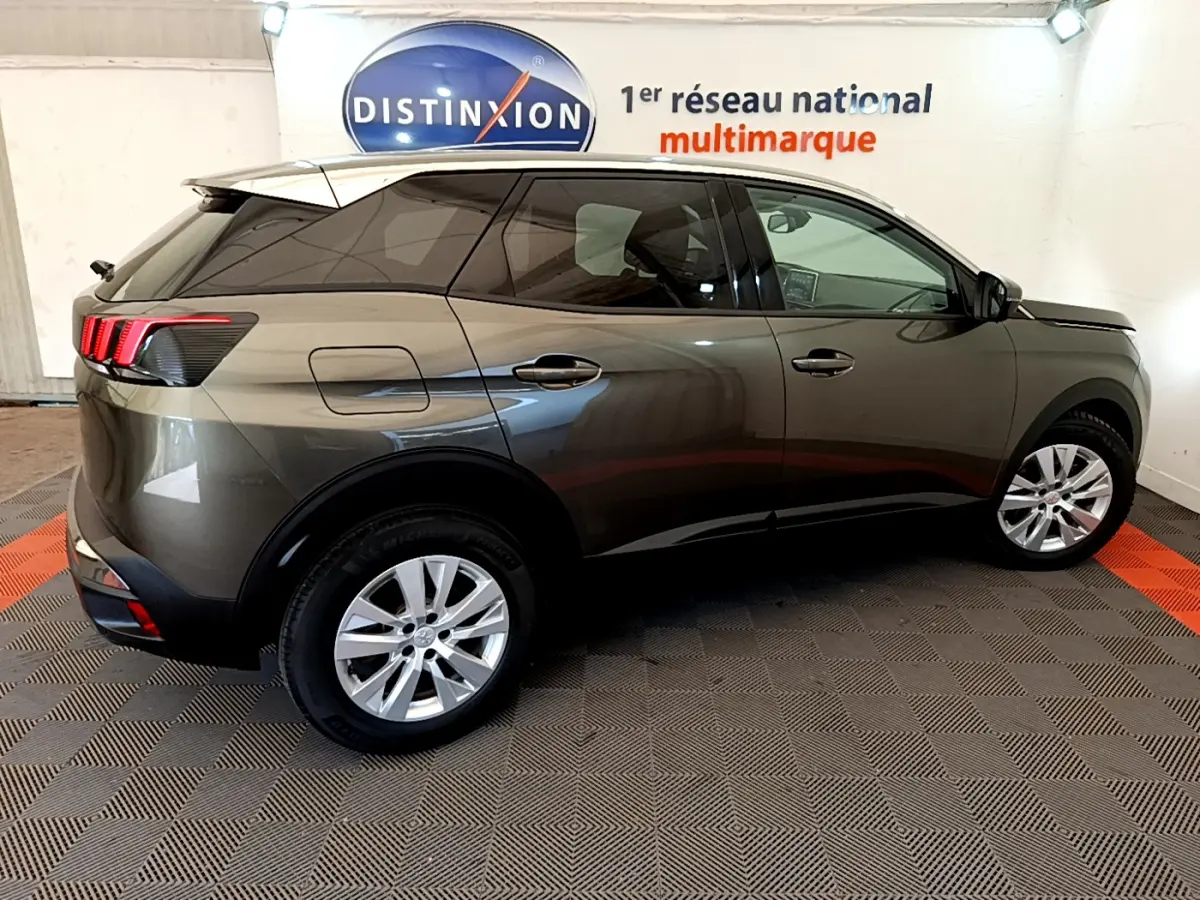 Peugeot 3008 gris foncé vue de profil côté droit, avec feux arrière à trois griffes rouges et jantes argentées.