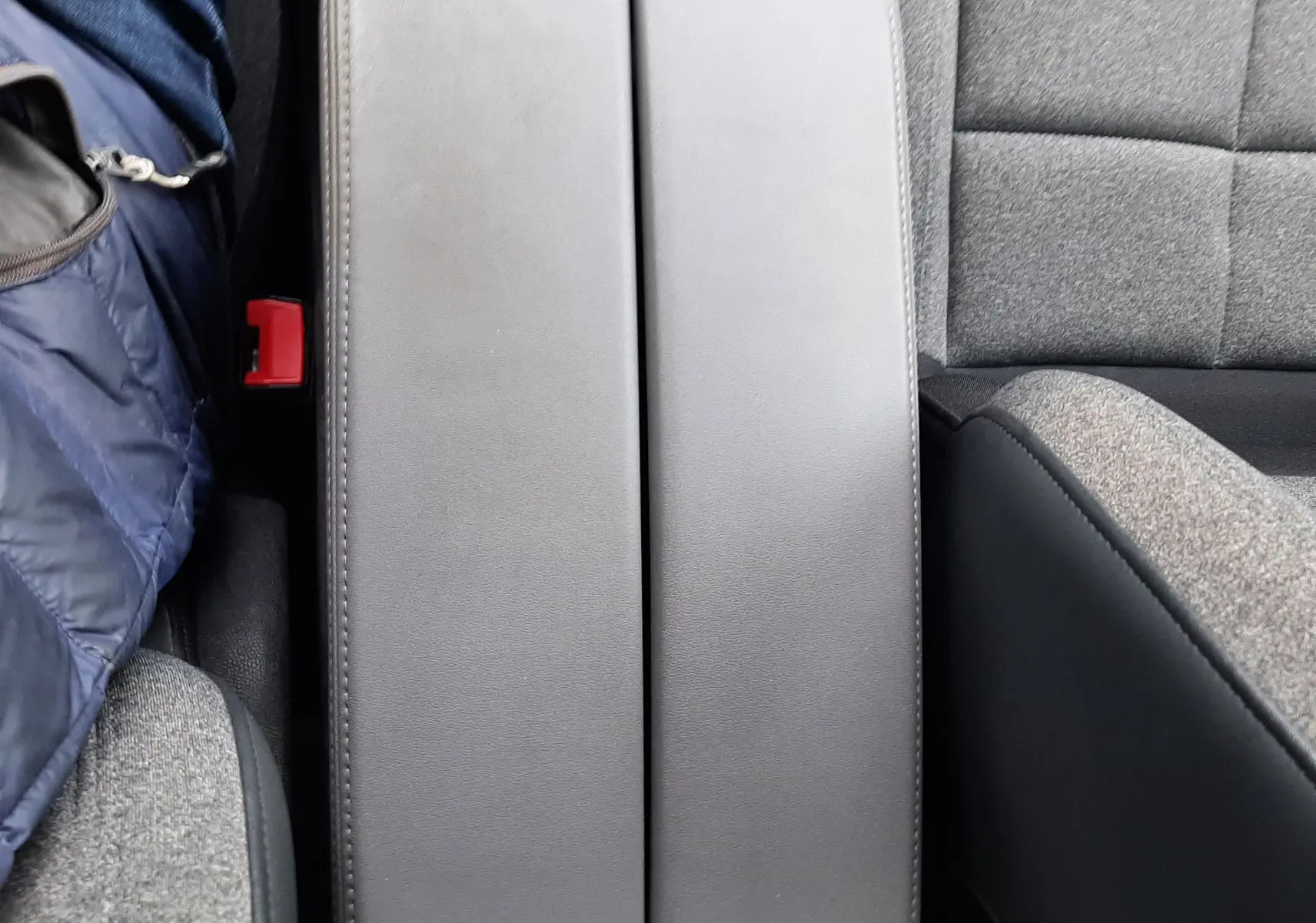 Vue rapprochée de l'accoudoir central en cuir gris entre les sièges tissu gris du Citroën C5 Aircross 2020.