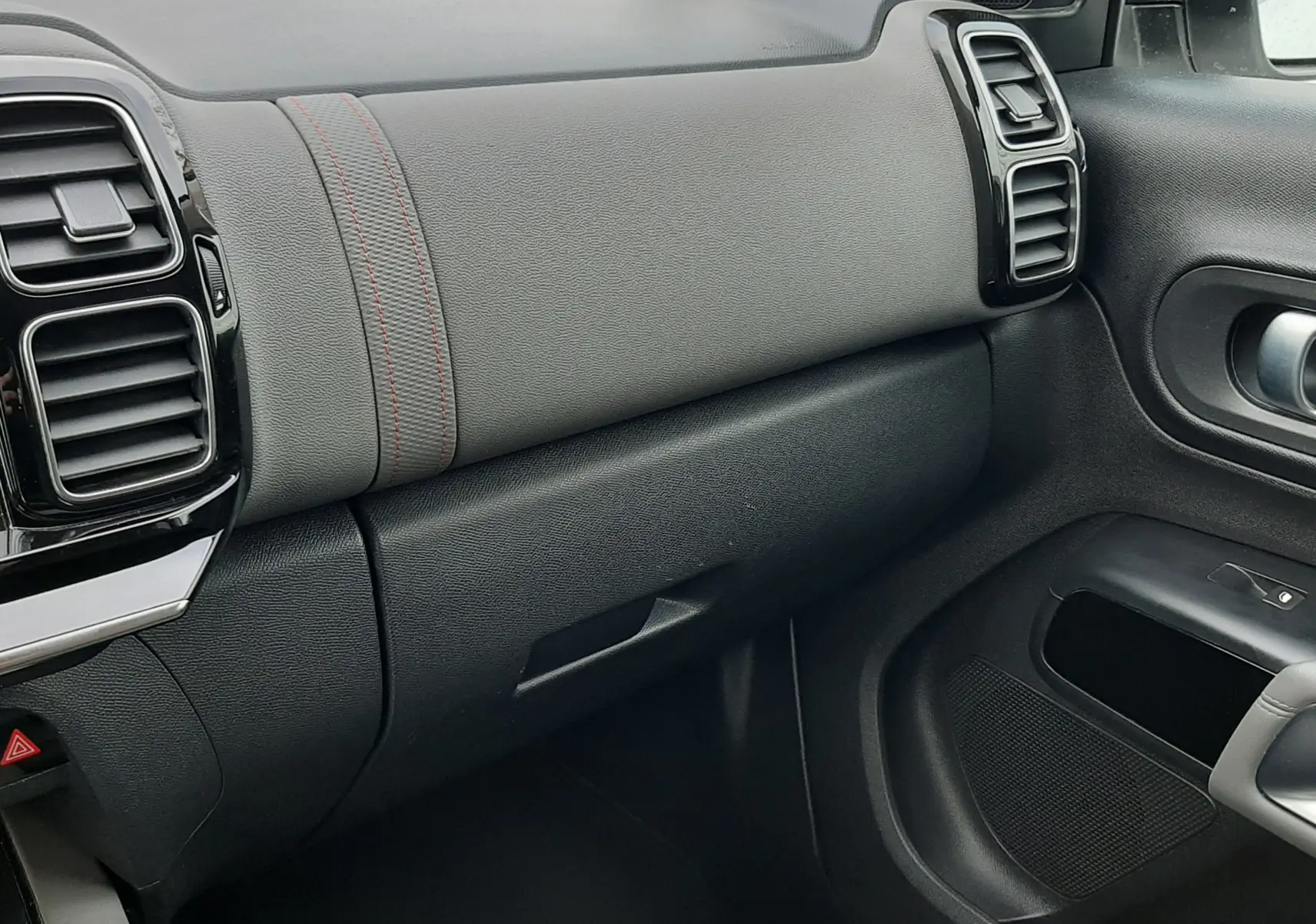 Vue intérieure côté passager du tableau de bord et de la portière d'un Citroën C5 Aircross blanc, finition tissu gris et détails noirs.