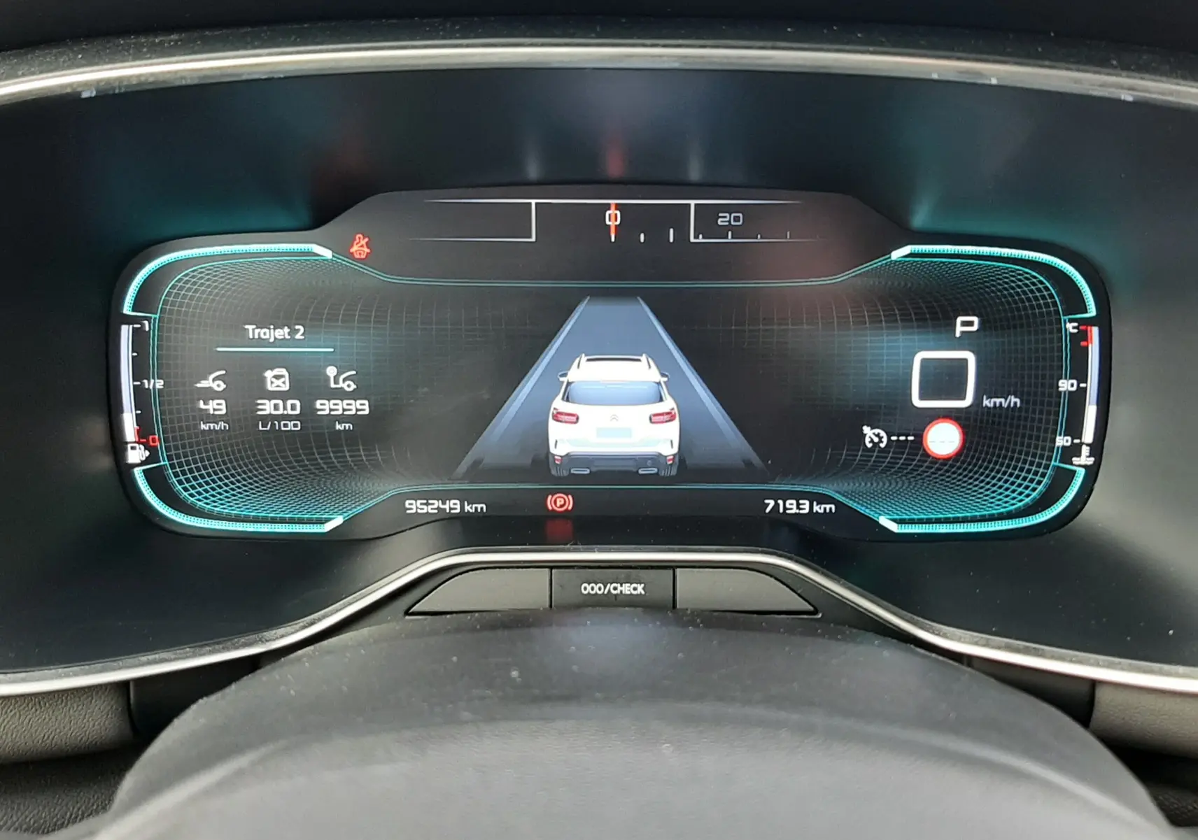 Vue rapprochée du tableau de bord numérique du Citroën C5 Aircross blanc, affichant la vitesse et l'assistance à la conduite.