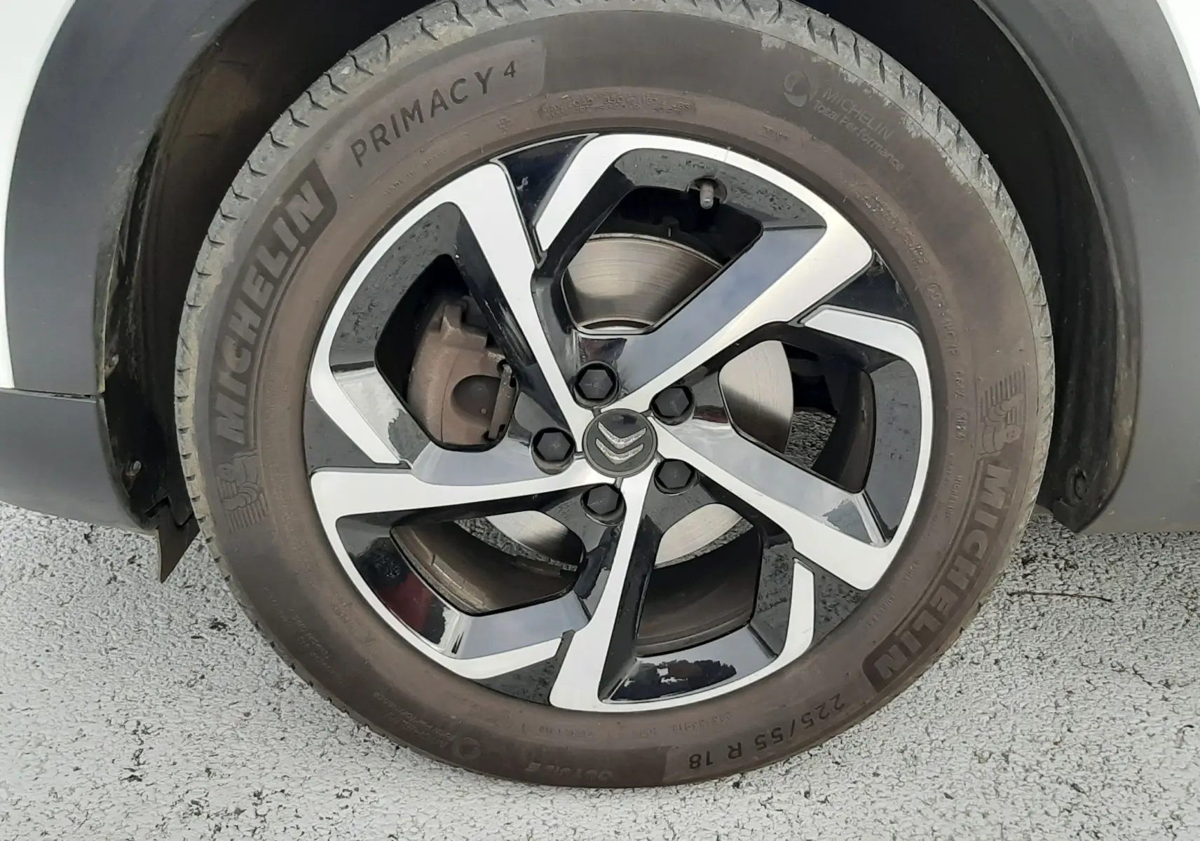 Gros plan sur la roue avant droite d'un Citroën C5 Aircross blanc avec jante alliage bicolore et pneu Michelin.