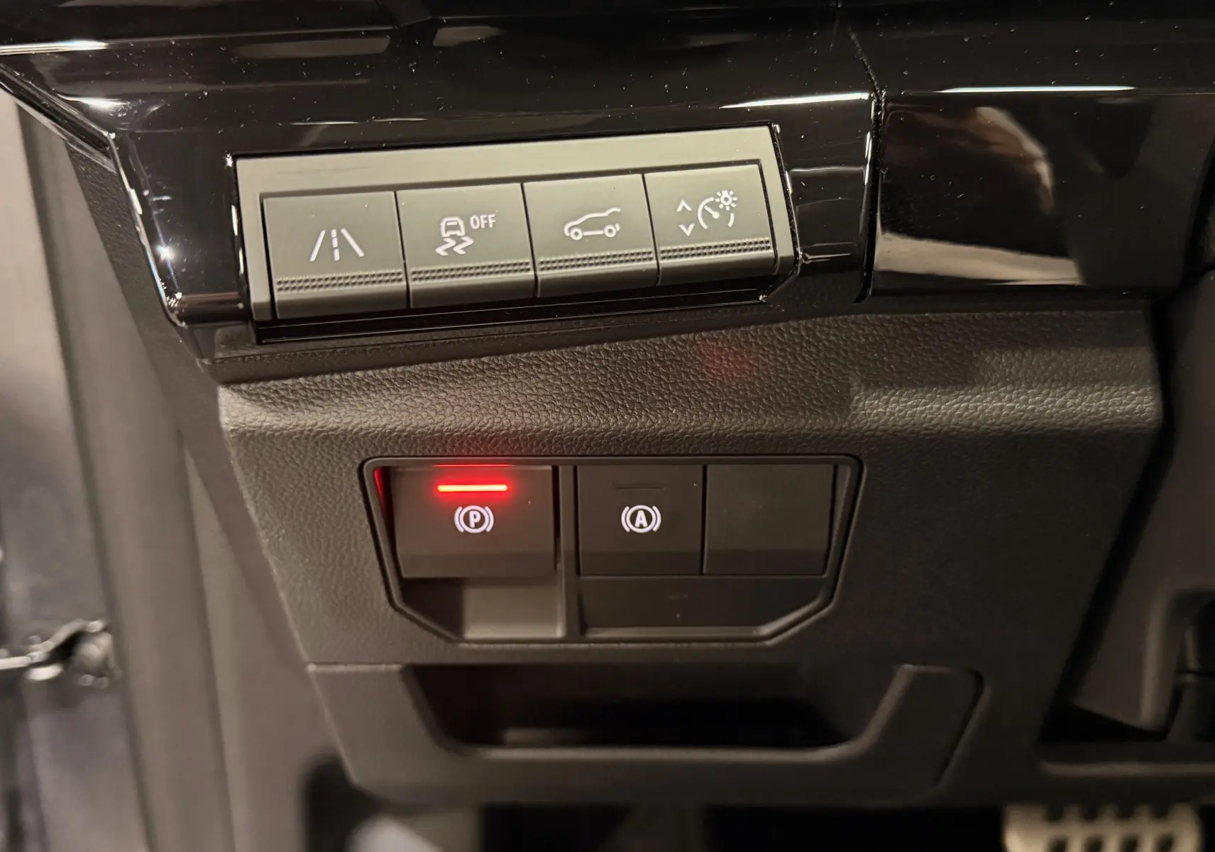 Gros plan sur les commandes de sécurité et d'assistance du tableau de bord du Renault Austral gris schist avec toit noir.