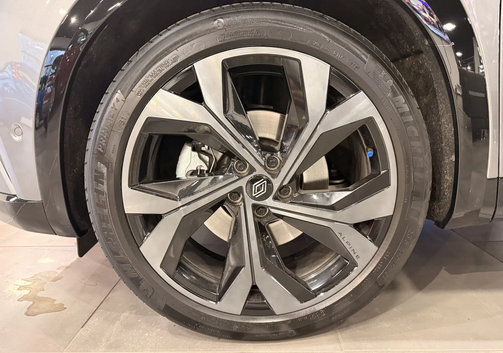 Gros plan sur la jante avant droite du Renault Austral E-Tech gris schist, avec logo Alpine et pneu Michelin.