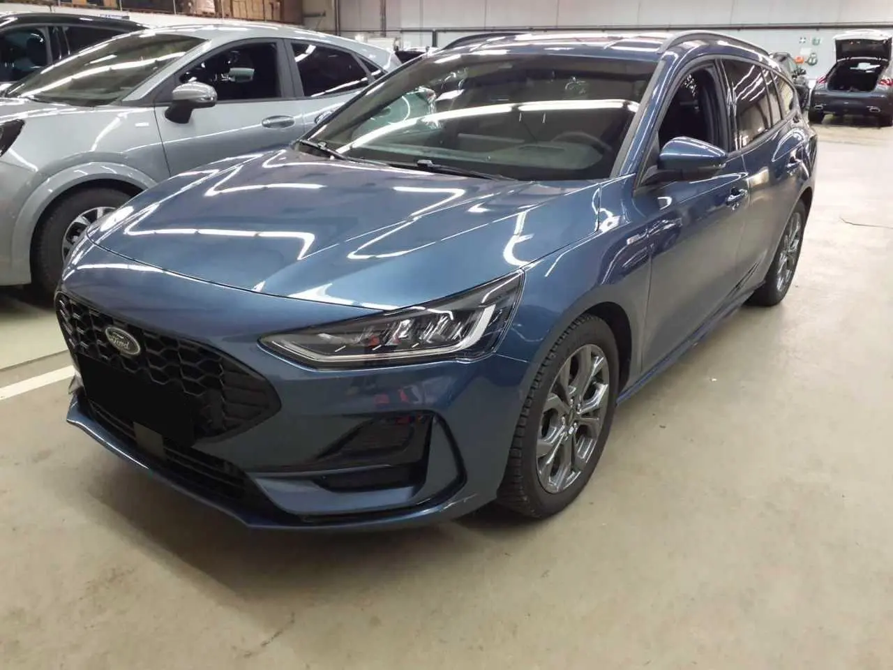 Ford Focus SW EcoBoost MHEV 125 ST Line X bleu azur vue 3/4 avant avec calandre noire et jantes alliage 17 pouces.