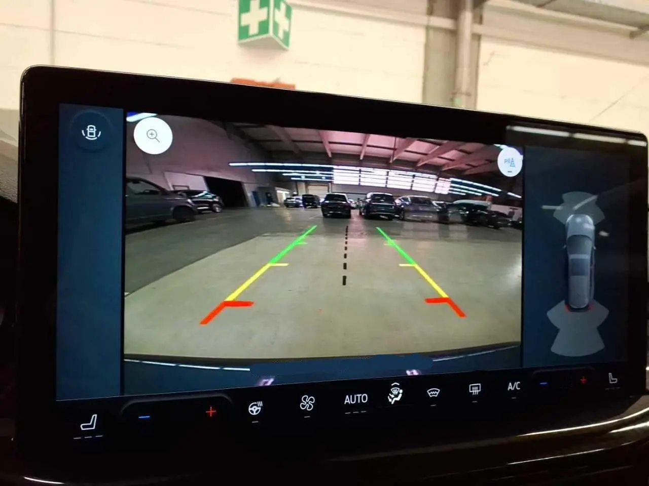 Vue de l'écran de caméra de recul du Ford Focus SW bleu azur, avec lignes d'aide au stationnement et attelage visible.